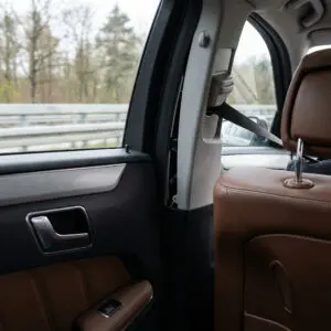 Eine störend vibrierende Kunststoffverkleidung im Heck eines fahrenden Kombis löst sich sichtbar von der Seitenwand.